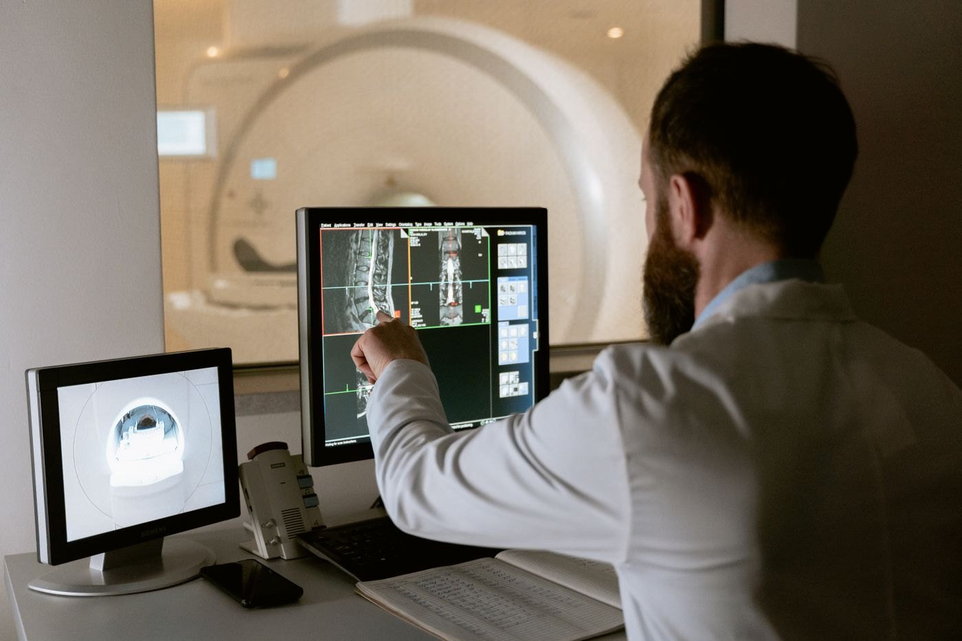 Medical imaging studies under review on multiple workstation screens.